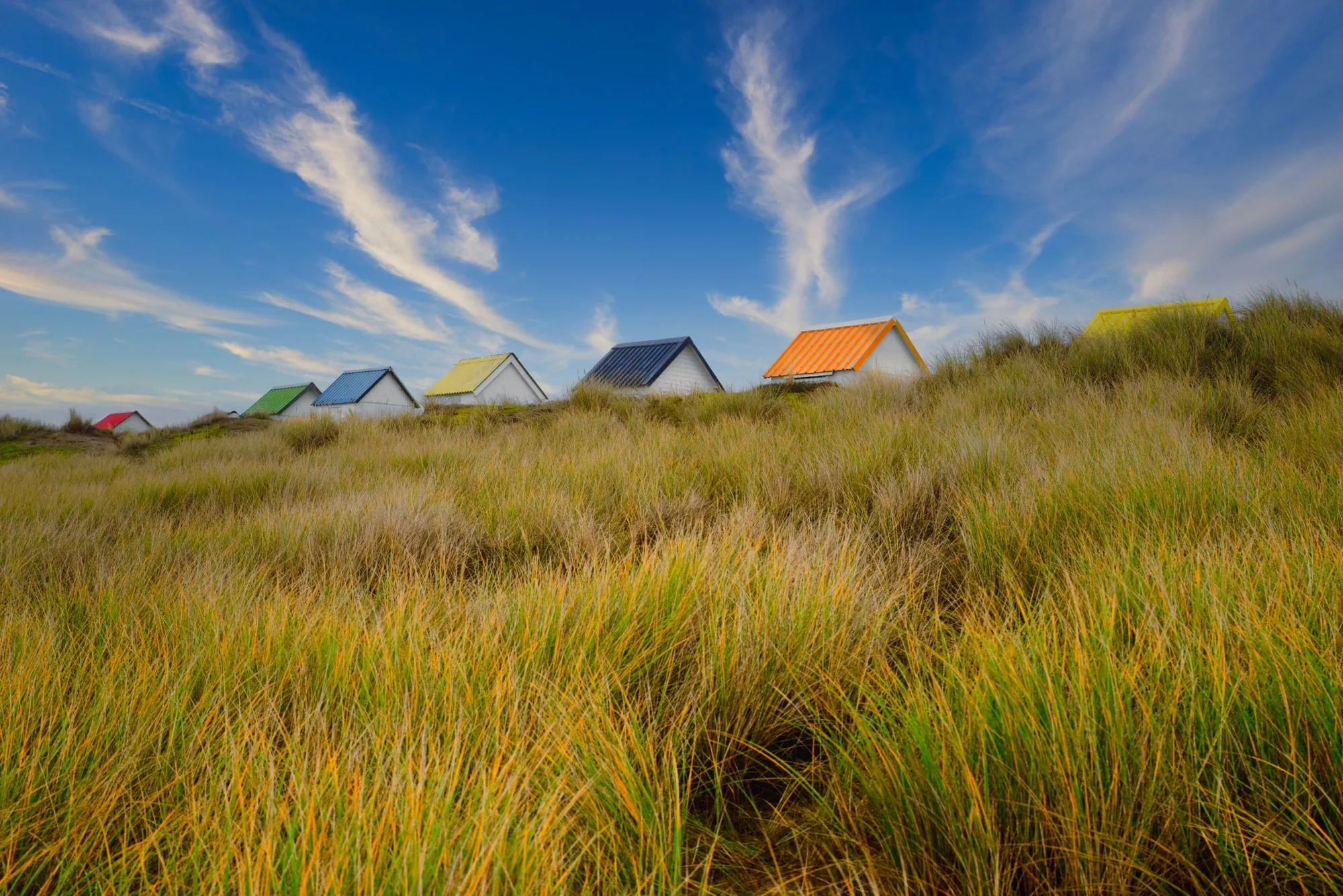 Bringing vibrant color to a seaside scene: beach cabins before and after retouching — RAW